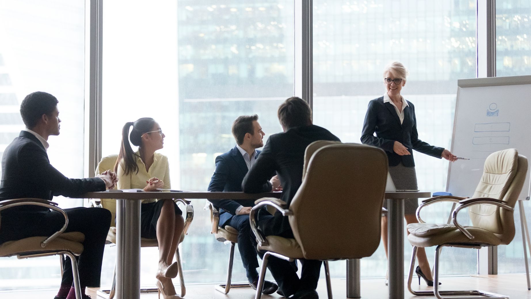 Business professionals in a meeting room, discussing performance management and governance strategies with a focus on core values.