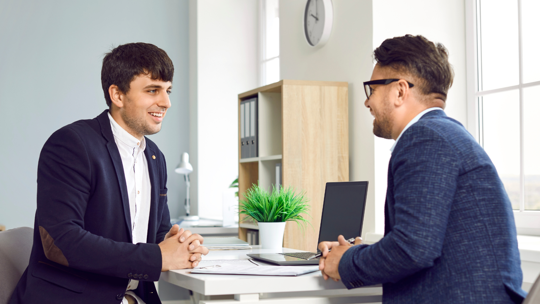 Male leader listening attentively to a team member during a one-on-one meeting.