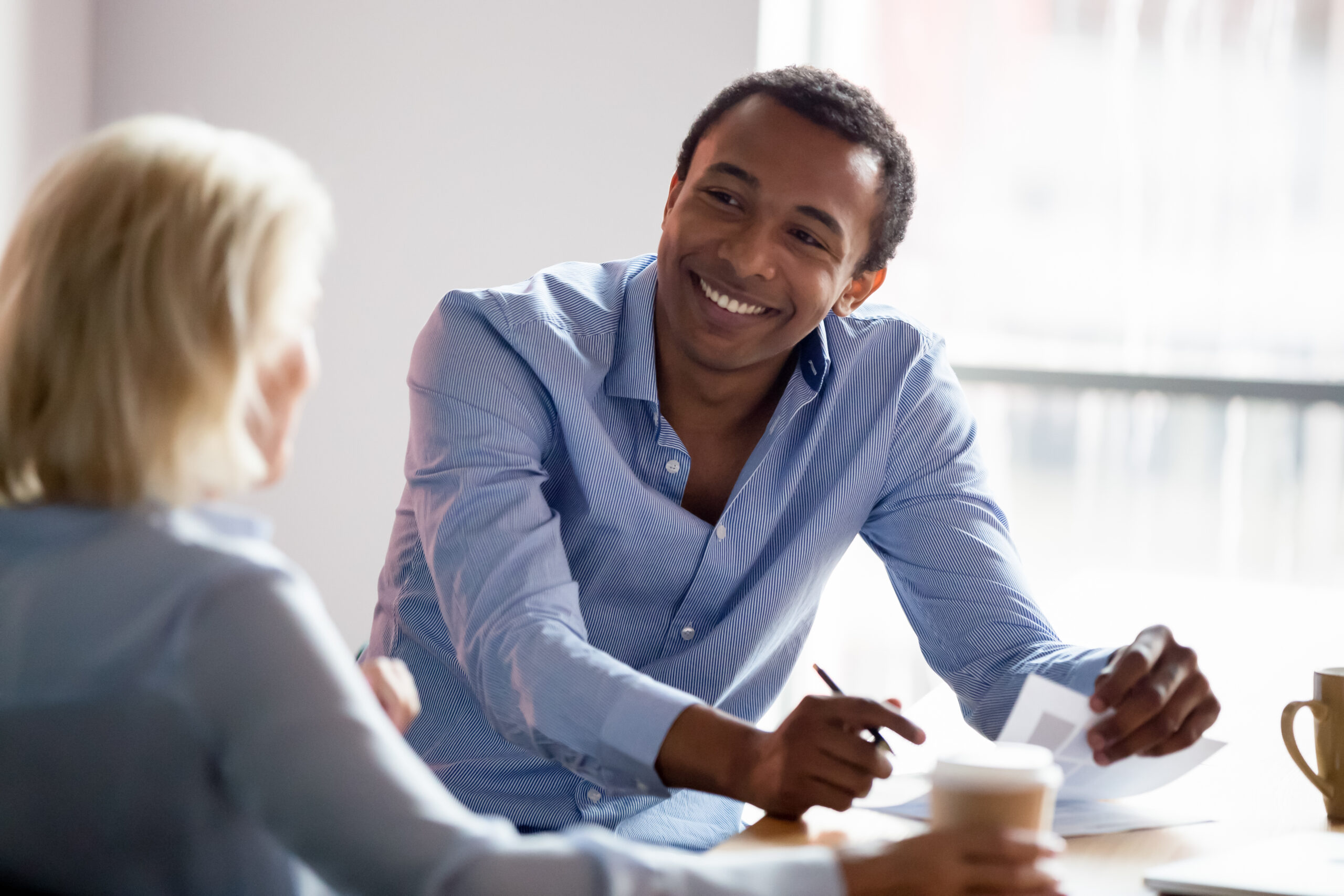 A professional smiling and engaging in a collaborative conversation, representing the human connection and teamwork central to a Customer Centric Strategy.