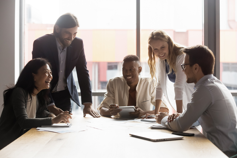 A group of professionals sharing a collaborative meeting, reflecting the positive impact of empathy in leadership on team dynamics and workplace culture.